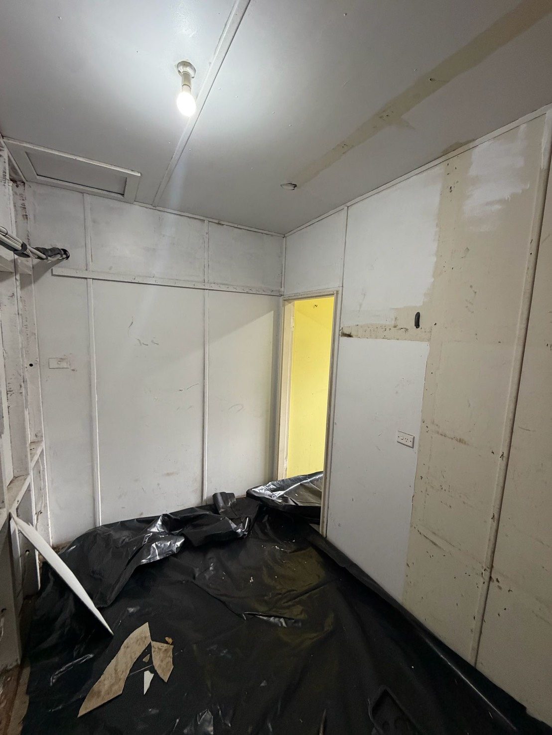 Room prepared with black plastic containment sheeting
