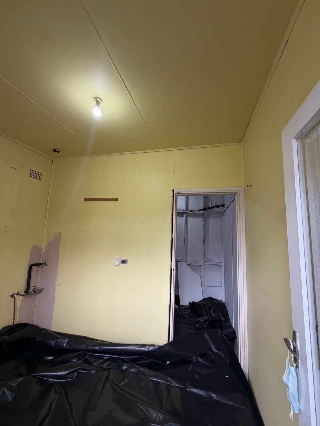 Room with yellow walls before asbestos removal begins
